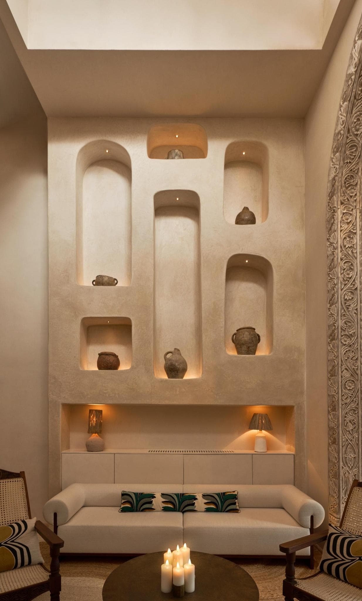 Plaster wall of lit niches holding old pottery